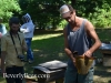 Brushing the bees off a comb of honey.